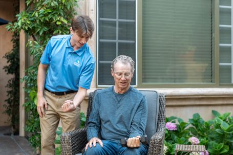 Caregiver encouraging a client lifting weights