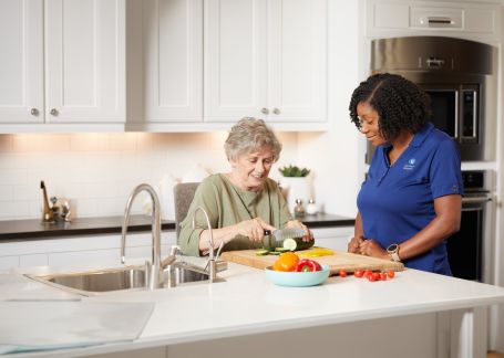 A Comfort Keepers caregiver and a senior woman cooking together in a home kitchen in Shrewsbury, NJ