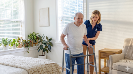 Comfort Keepers caregiver helping an older man with his mobility at home in Edison, NJ