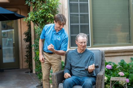 caregiver helping elderly person workout