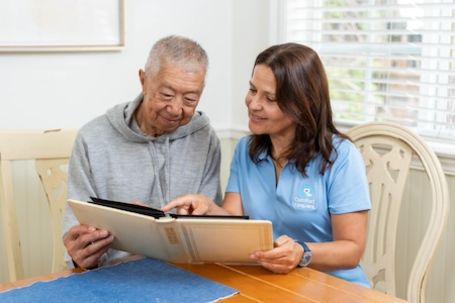 caregiver with client looking at an album