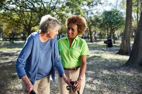 image of a caregiver helping a senior walk