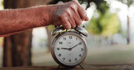 senior hand, holding clock