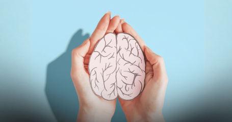 two hands holding a drawing of a brain