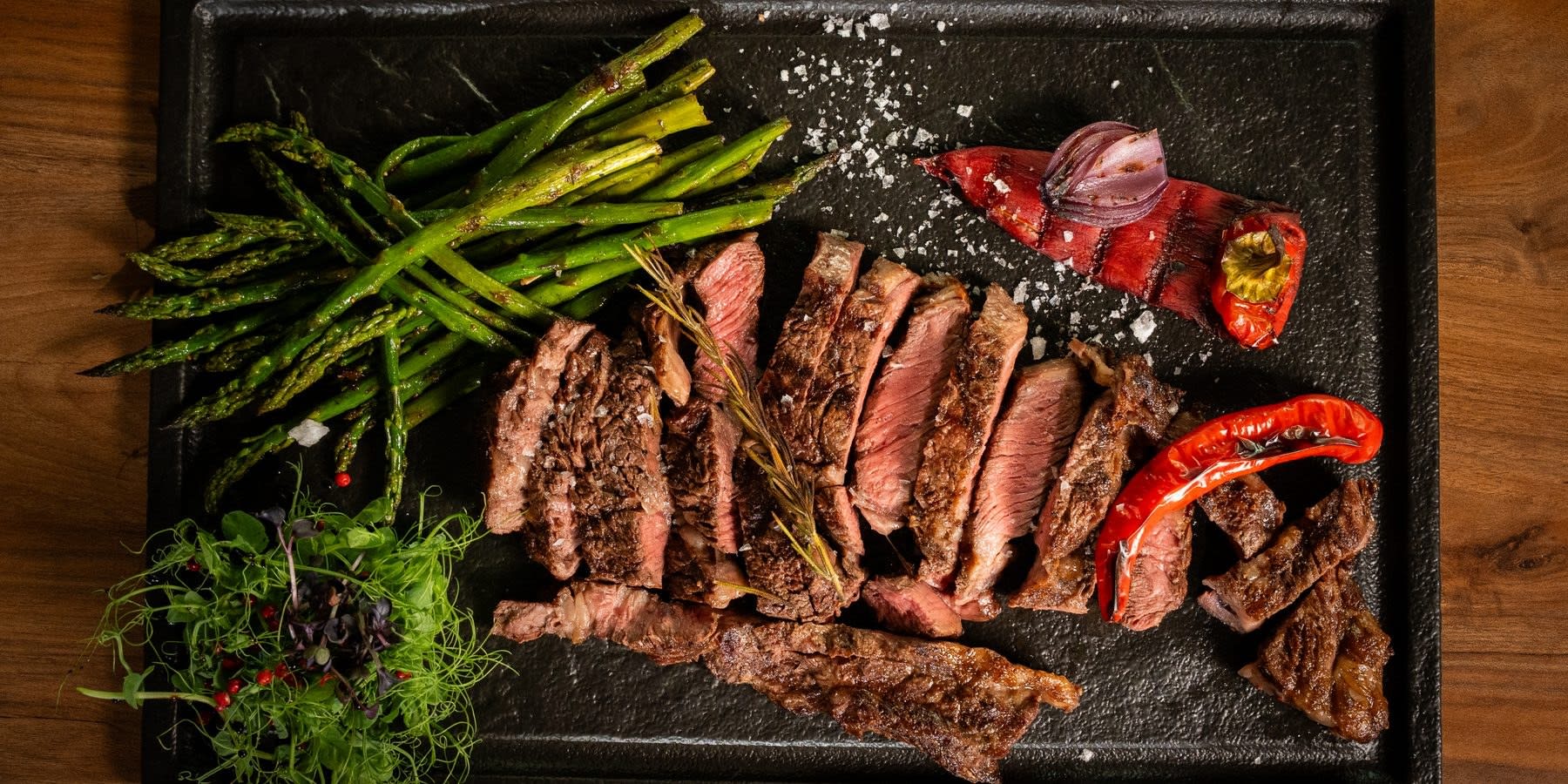 Ribeye cu os feliat pe fontă, cu sparanghel și ardei copt, la Transylvania Steakhouse Cluj-Napoca