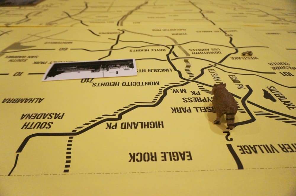 Guests seated around a giant map on a table (detail)