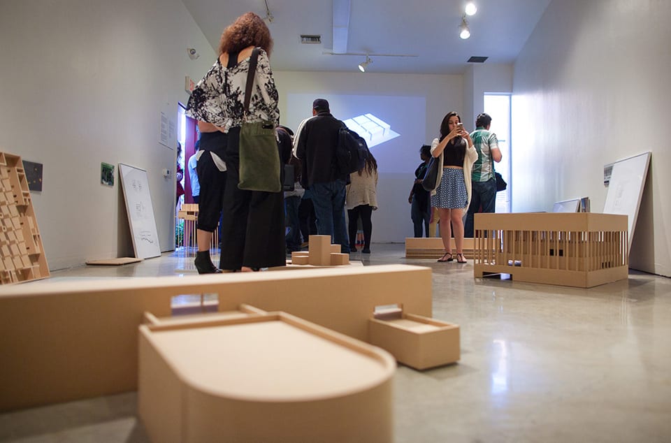 People looking at architectural models in gallery