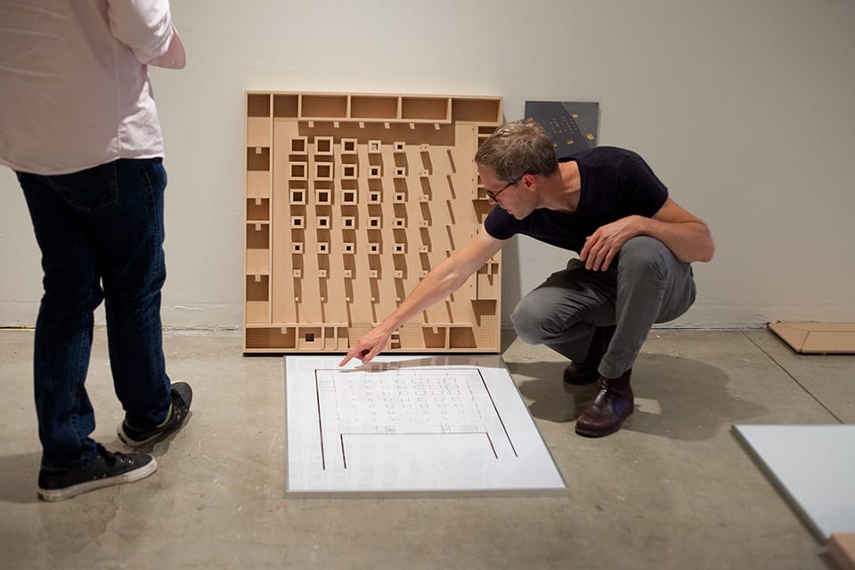 People looking at architectural models in gallery