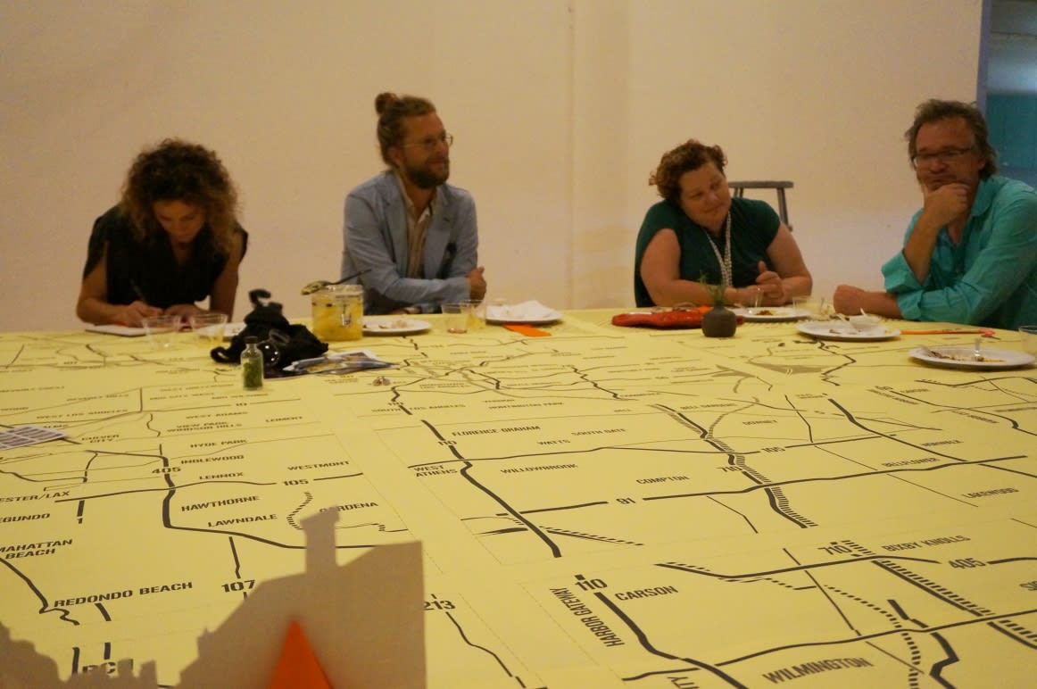 Guests seated around a giant map on a table