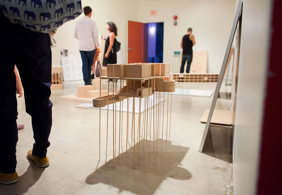 People looking at architectural models in gallery