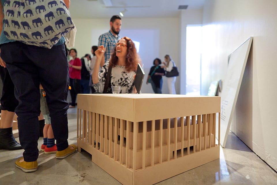 People looking at architectural models in gallery