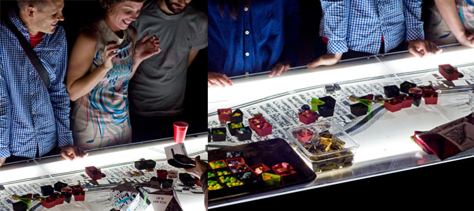 People looking at candy on maps printed on multi-colored paper