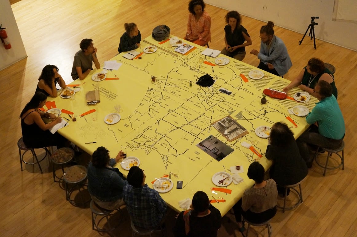 Guests seated around a giant map on a table