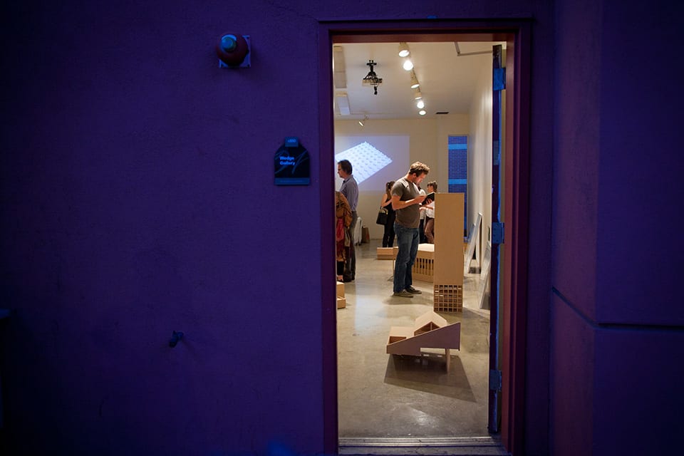 People looking at architectural models in gallery