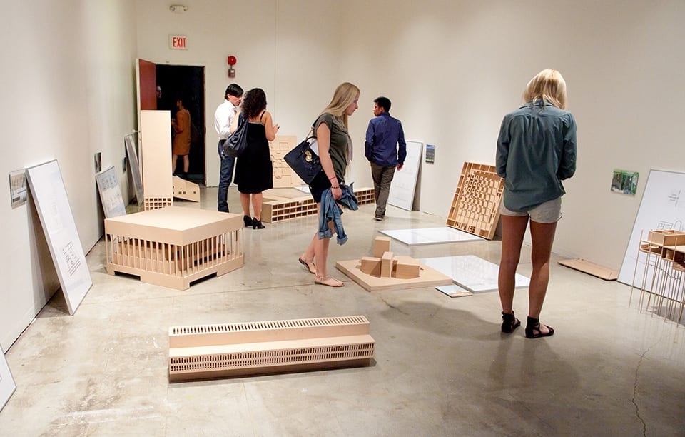 People looking at architectural models in gallery