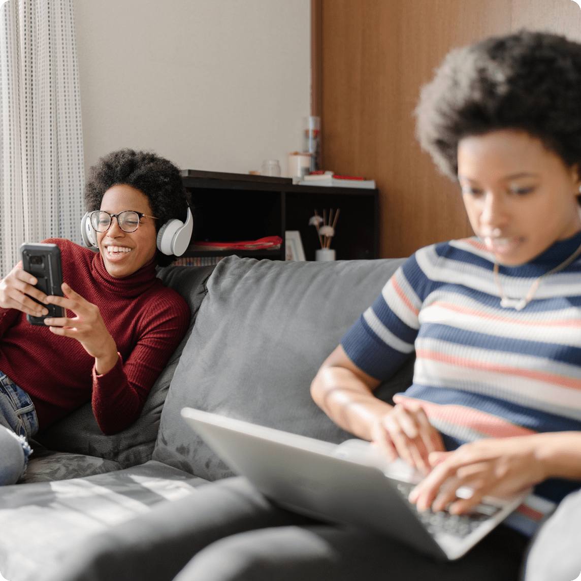 family sitting on couch using smart devices