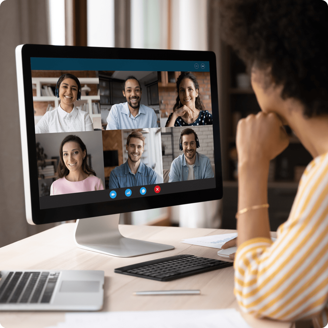 A woman sits at her computer while on a virtual meeting with co-workers.