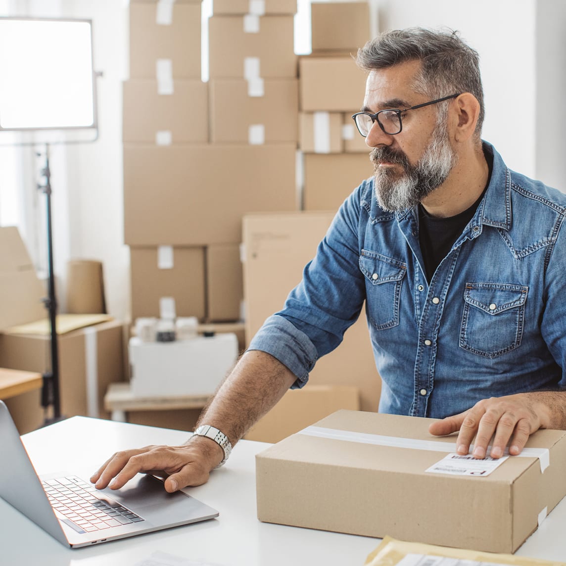 business owner entering packaging data on laptop