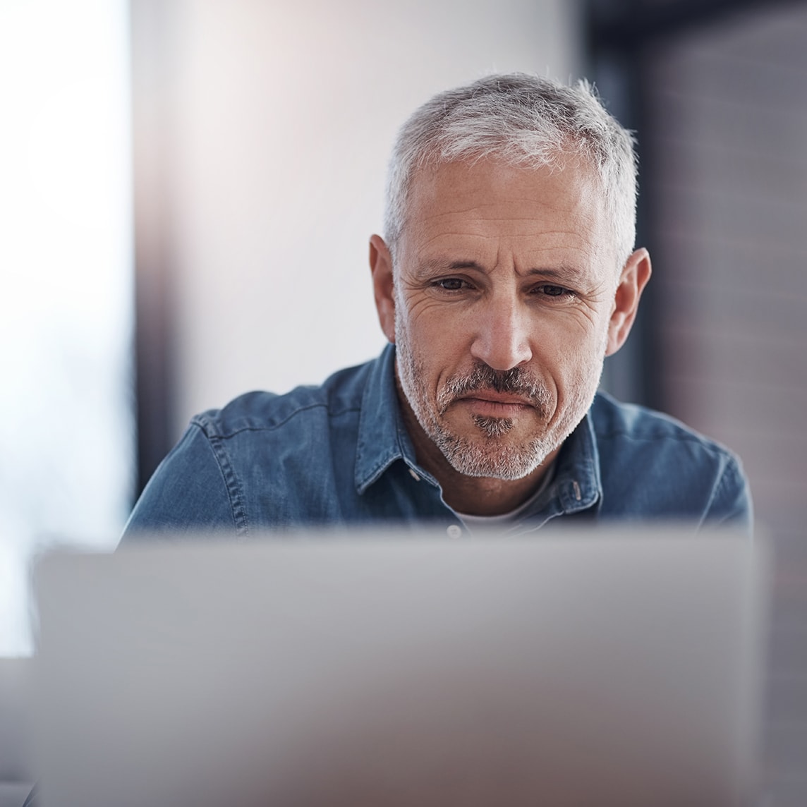 Man focused on laptop screen