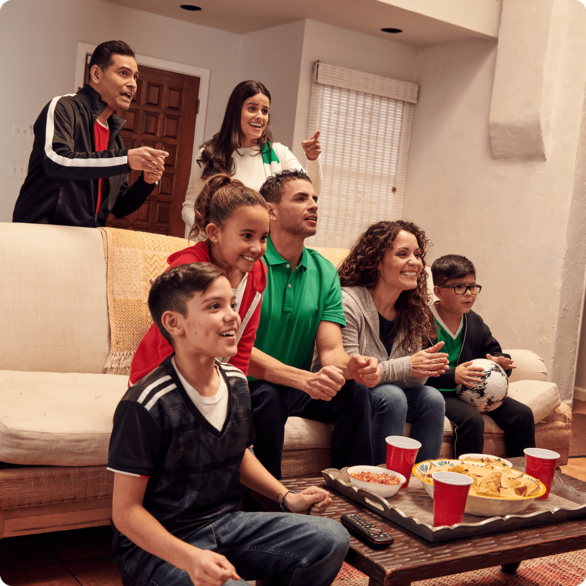 Familia viendo un partido de fútbol juntos.
Family watching a soccer match together.