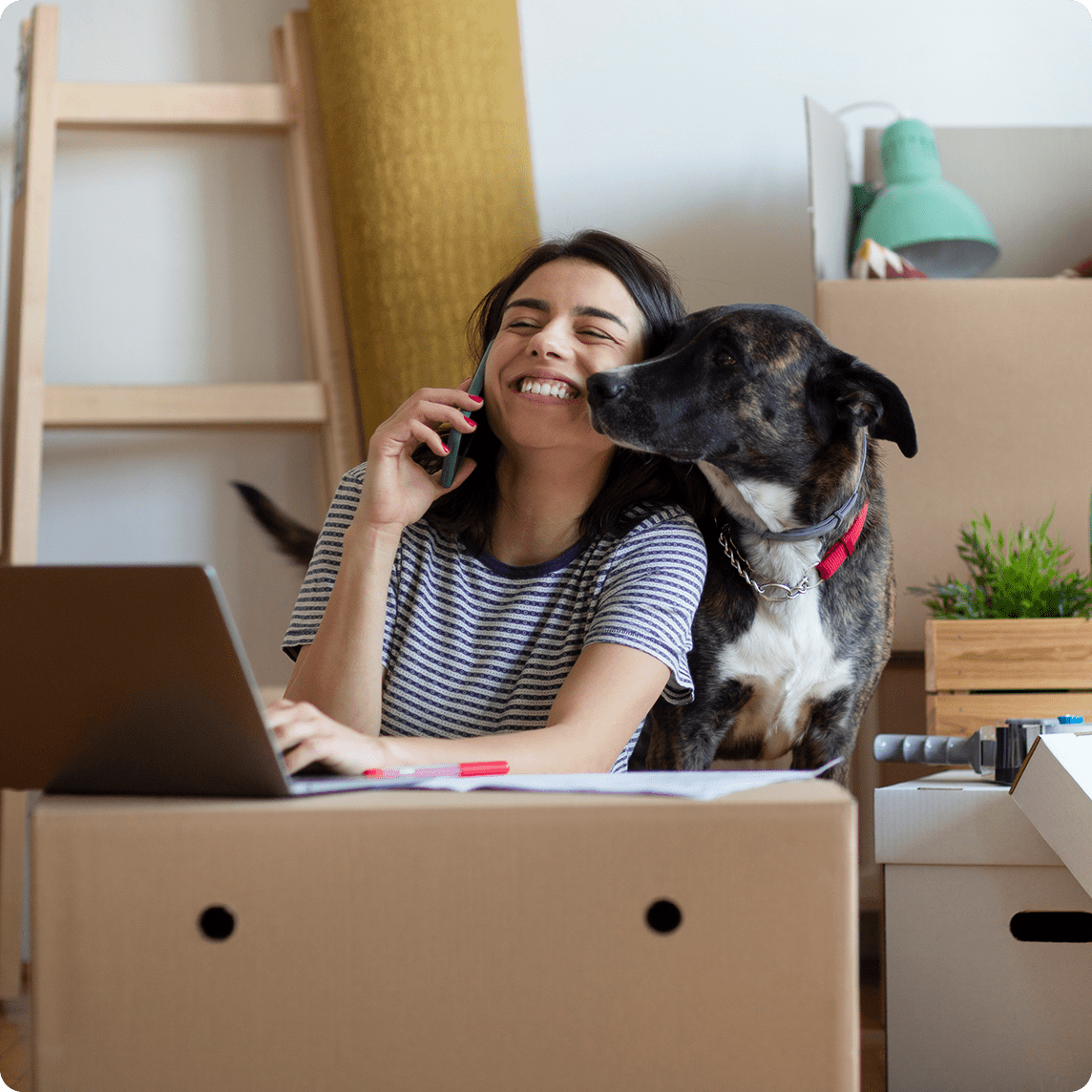 Man sitting on couch with his dog working on the computer