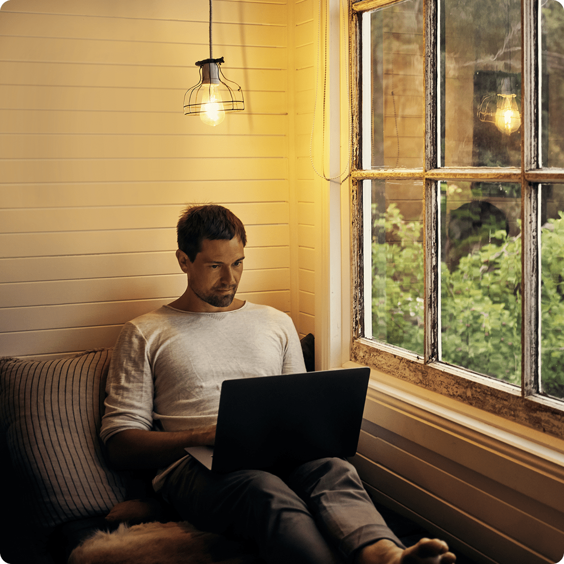 Man using laptop by window