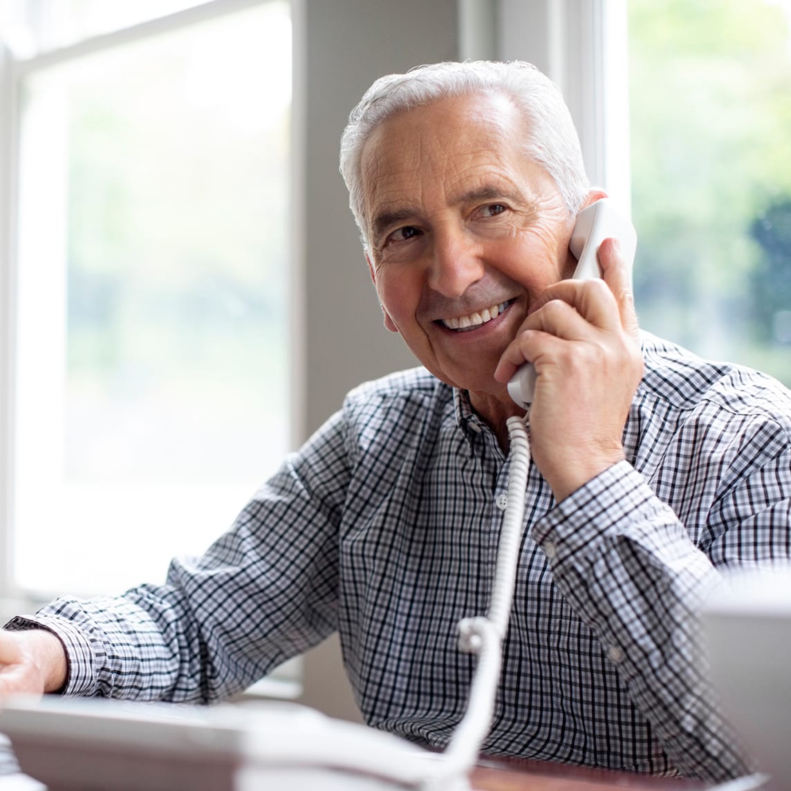 mature man talking on landline phone