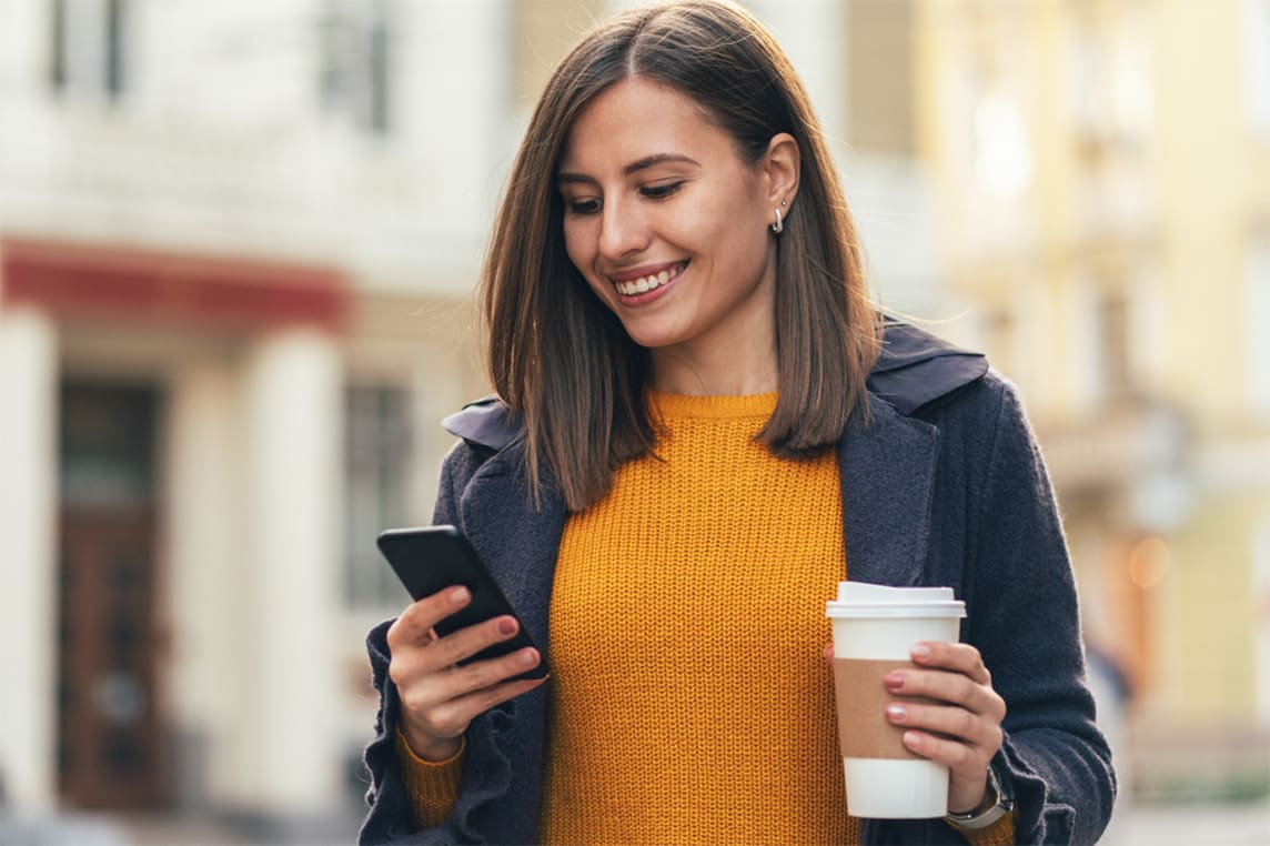 Woman with phone and coffee.