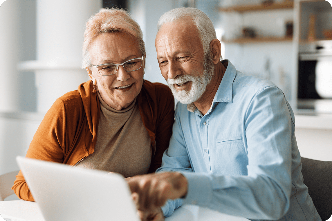 Senior couple uses laptop with fast internet at home.