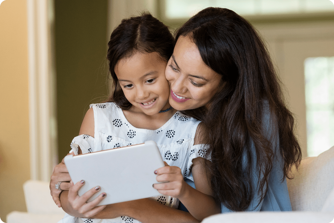 Madre ayudando a establecer controles parentales con la tableta de sus hijas. Mother helping establish parental controls with daughters tablet.