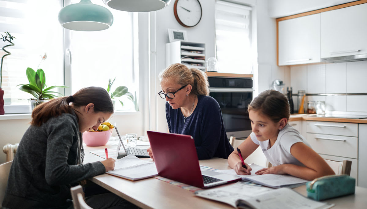 family in kitchen on laptops