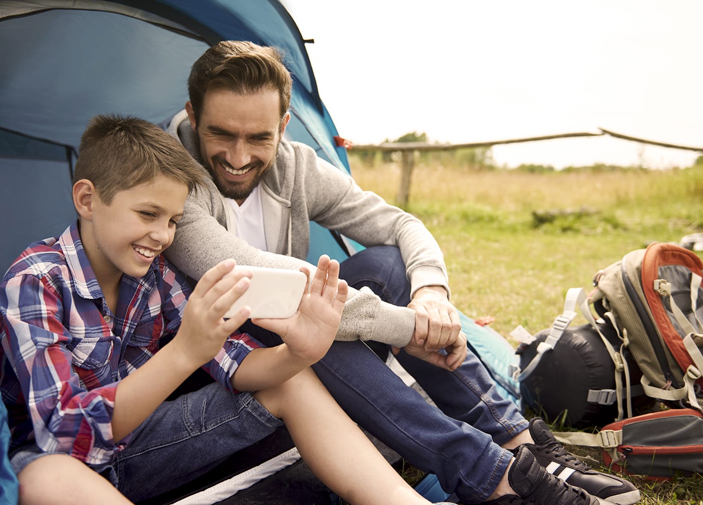 father and son watching tv on phone