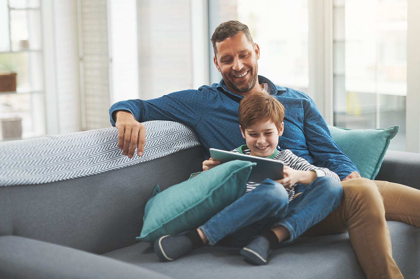father and son watching tv on tablet