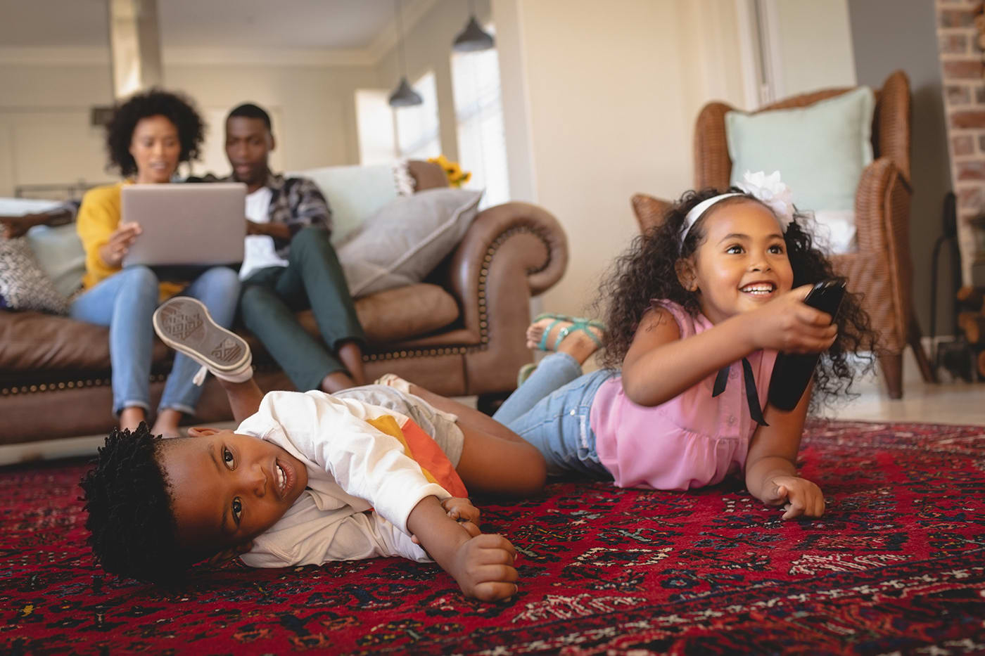 kids watching tv with parents in background