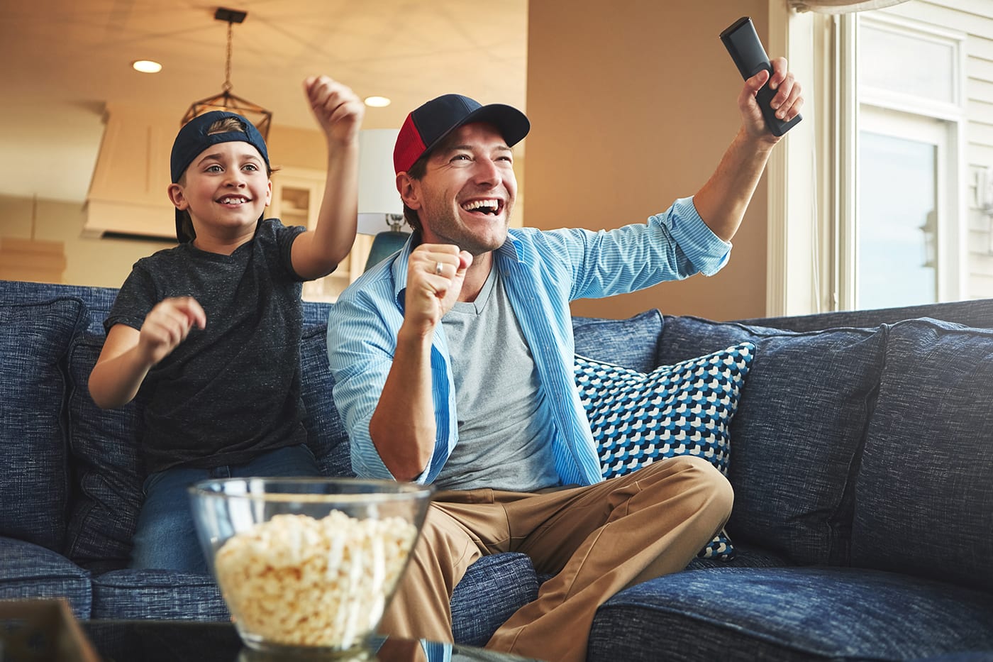 Father and son watching tv and cheering