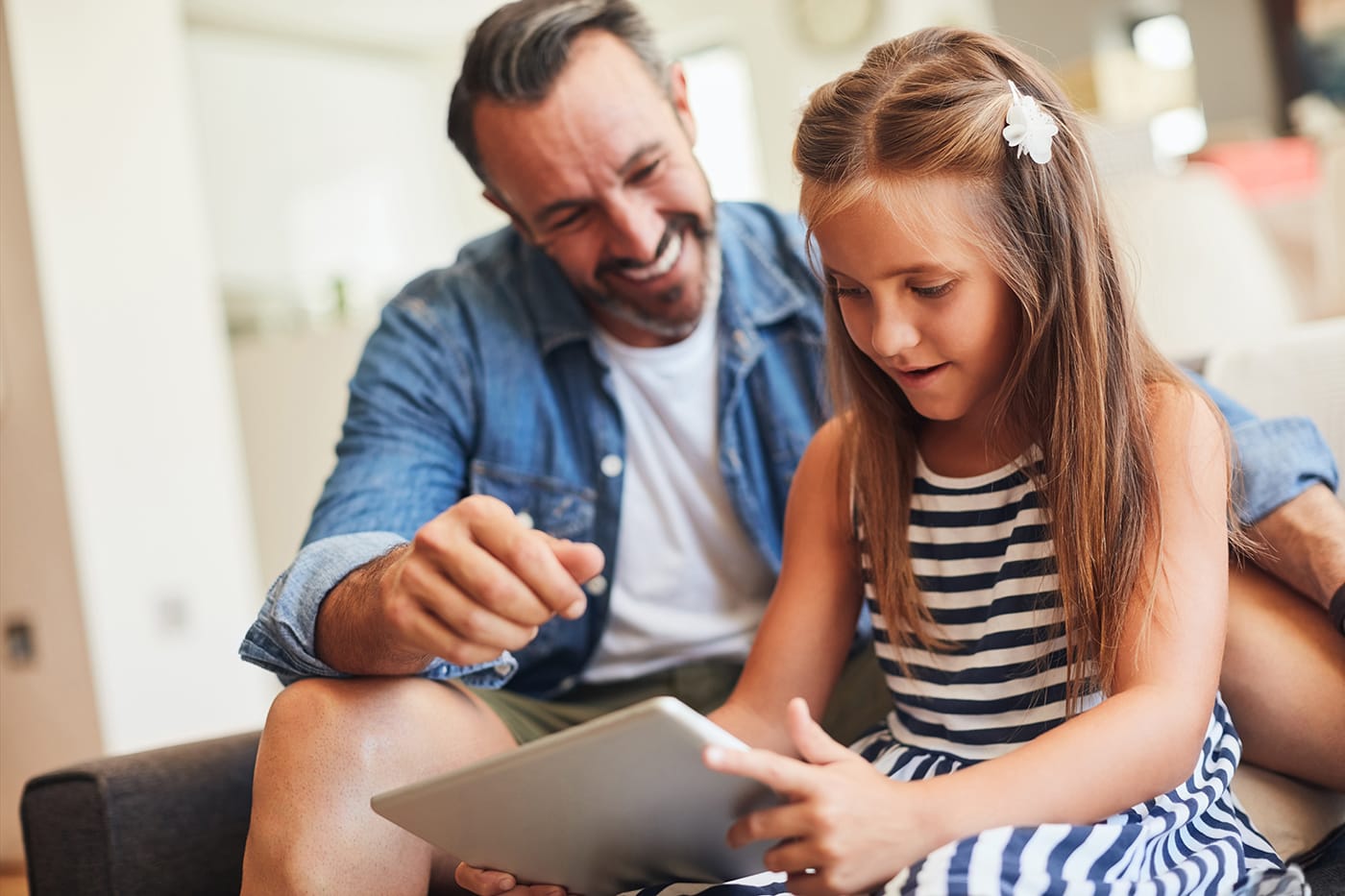 father and daughter watching tv on tablet