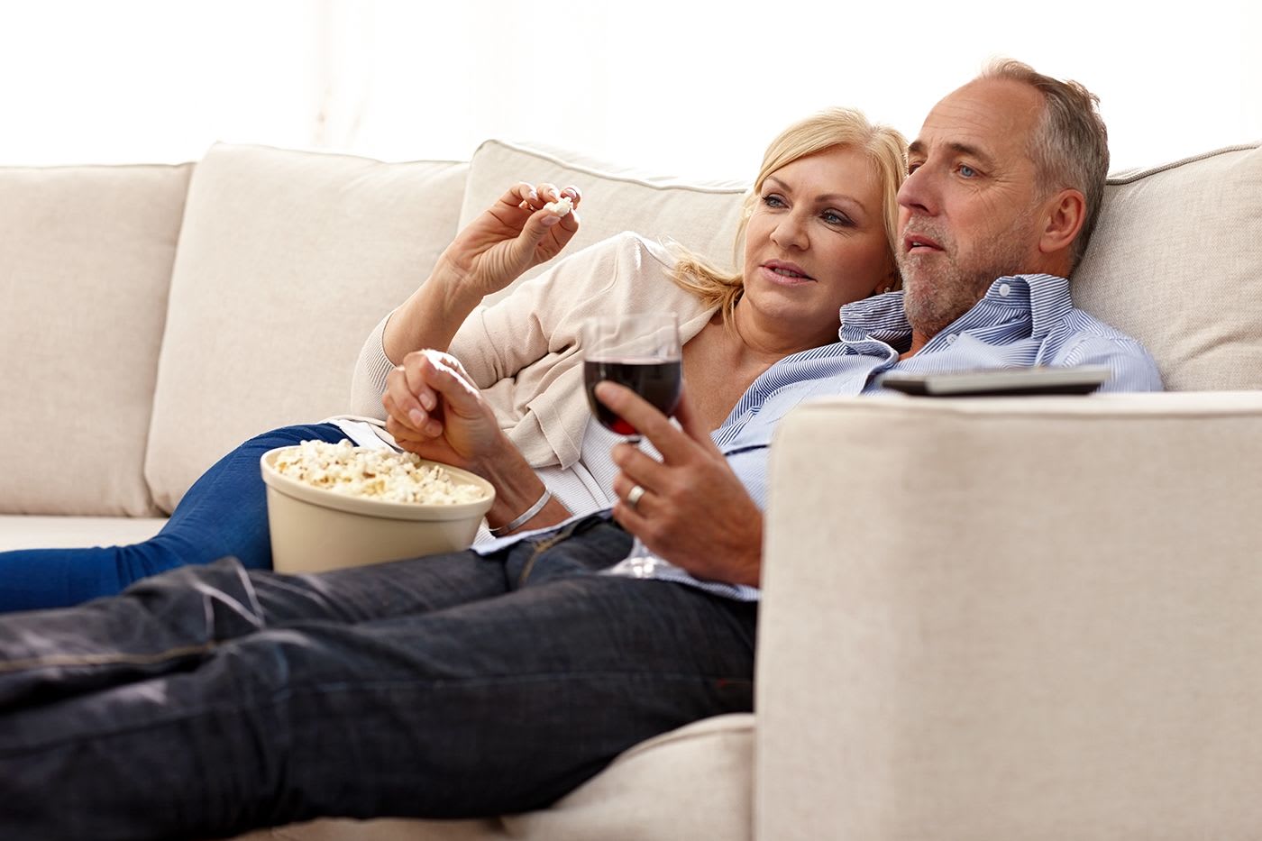 couple watching movie while enjoying popcorn and wine