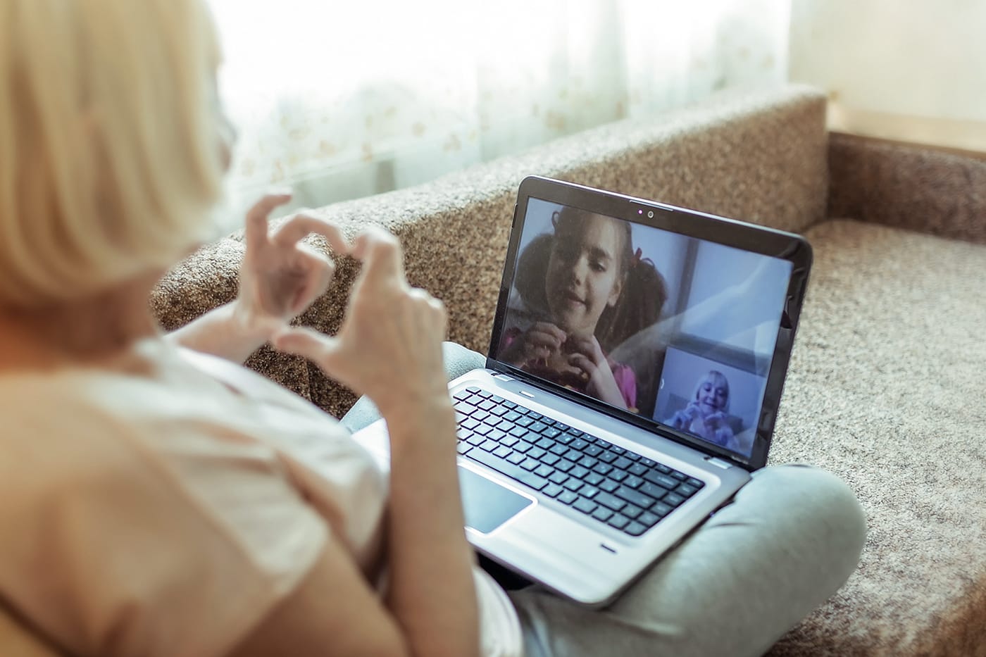 women on couch video conferencing with grand daughter