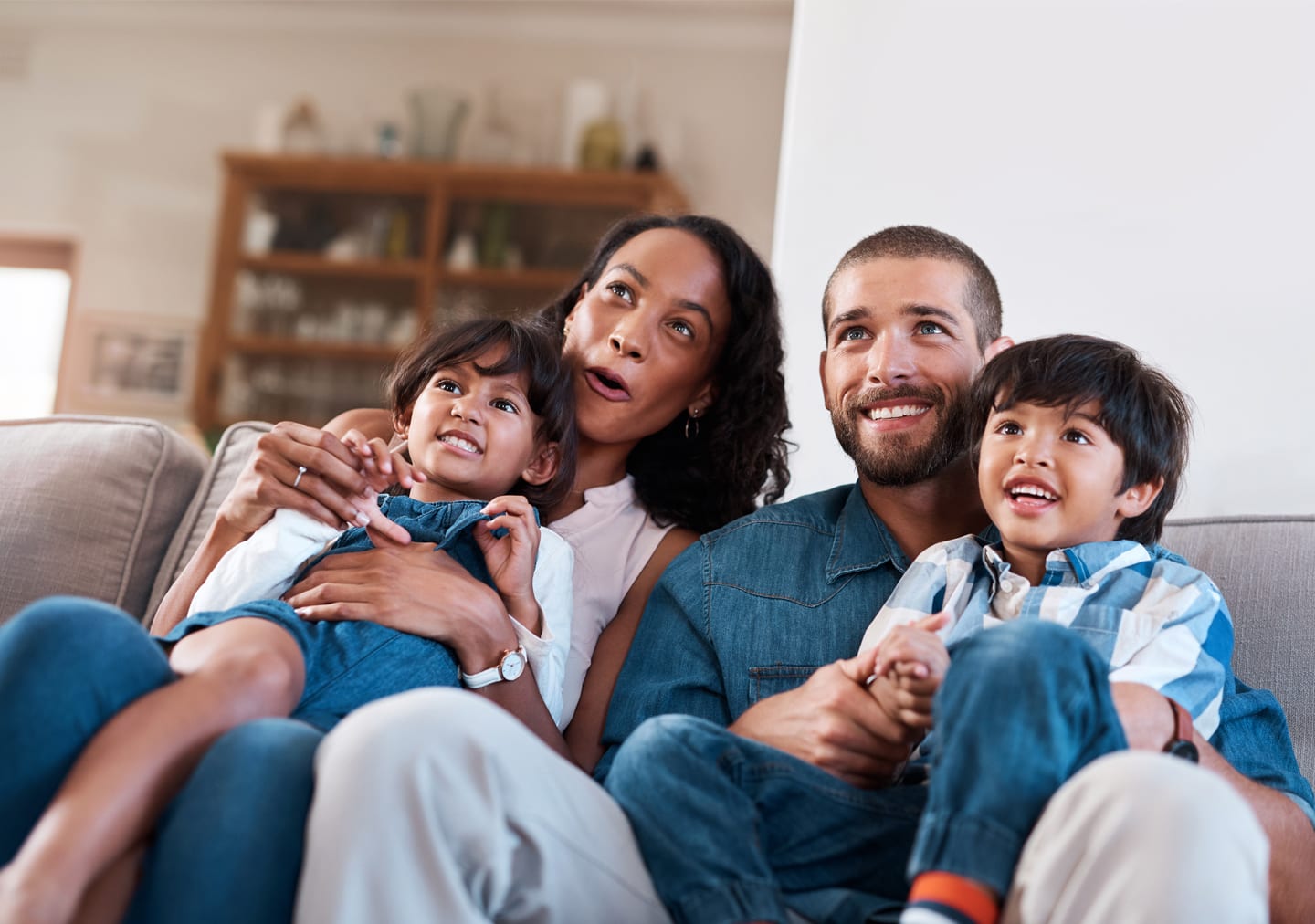 Una familia con dos niños pequeños disfruta juntos de una película divertida. A family with two little kids are enjoying a fun movie together.