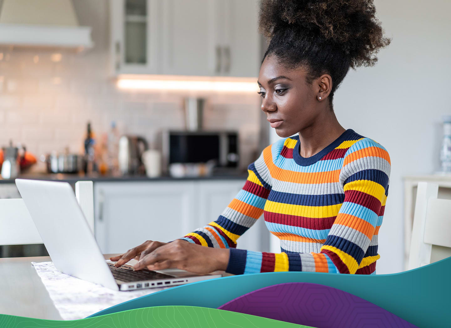 woman typing on laptop on kitchen table