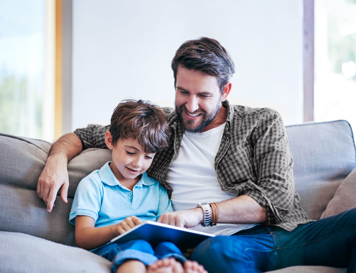 father and son on couch using CenturyLink internet