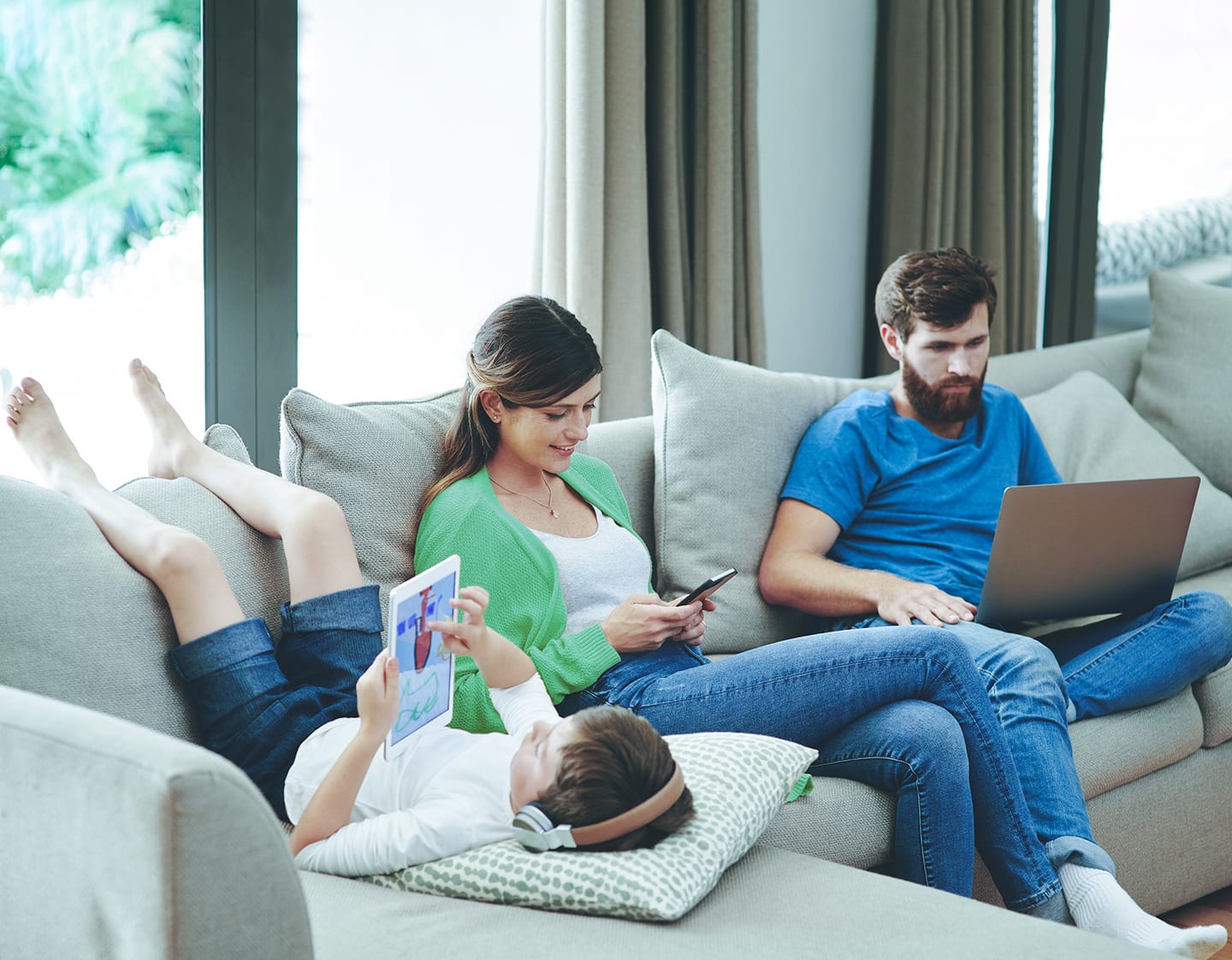 family on the couch using devices to access CenturyLink internet service