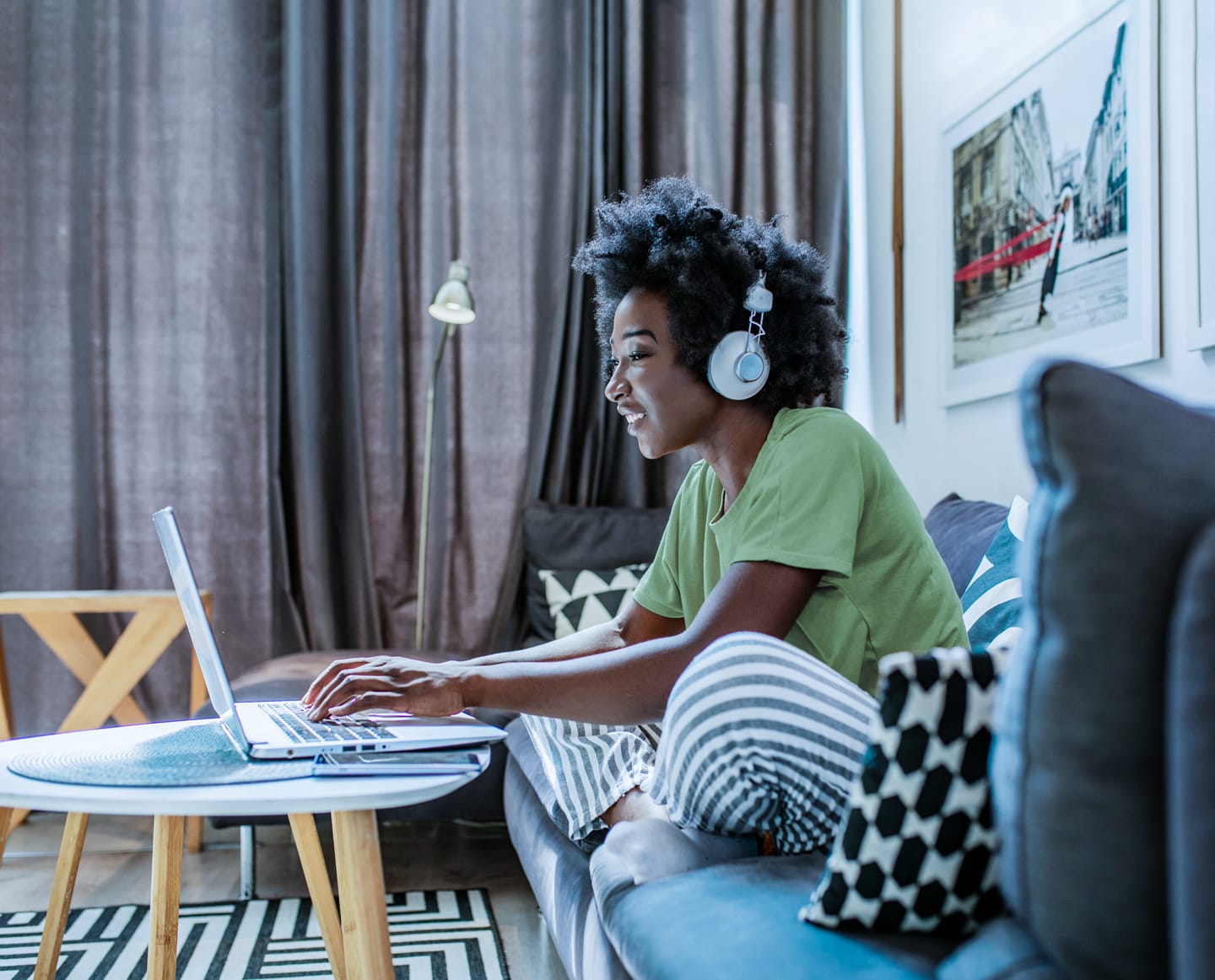 Woman with headphones working on her laptop using CenturyLink internet