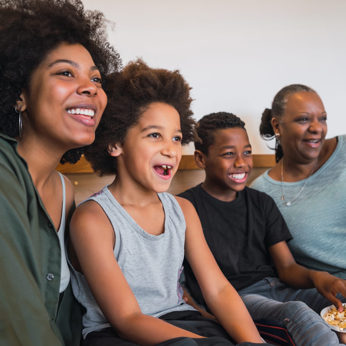 Family enjoying TV together and enjoying popcorn