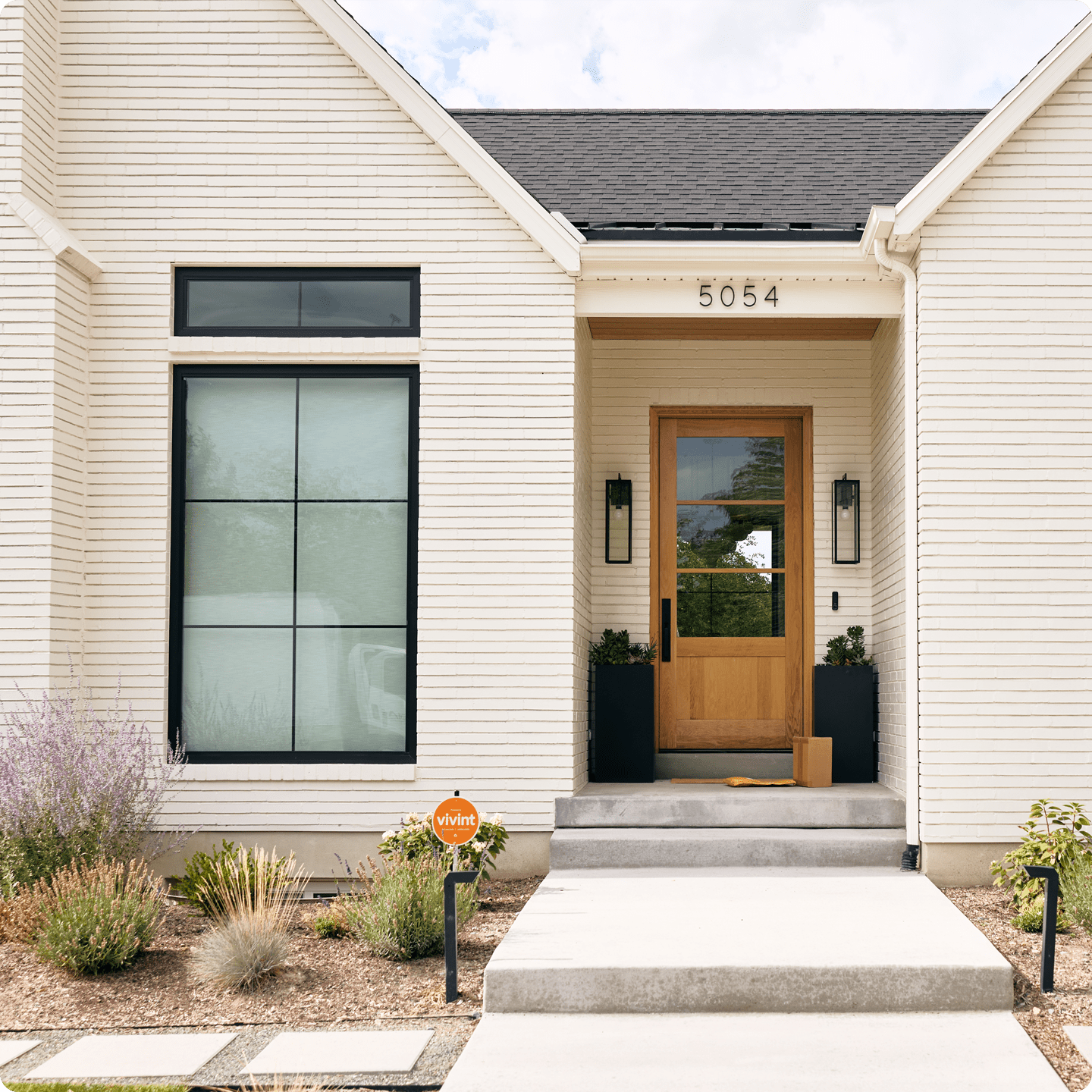 White Brick home with vivint sign in the yard