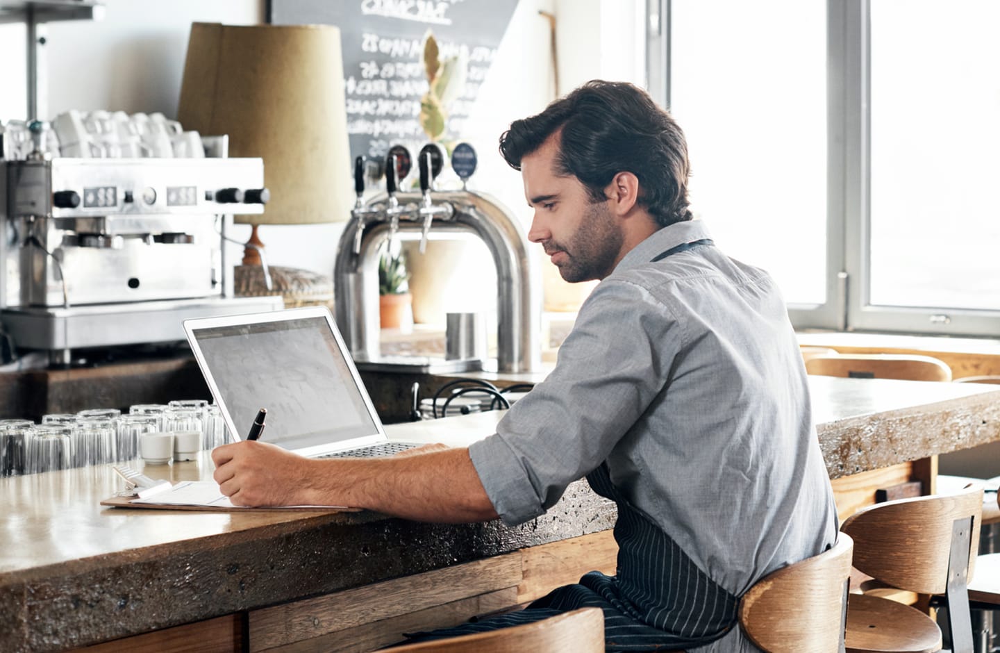 Bar owner taking inventory on laptop