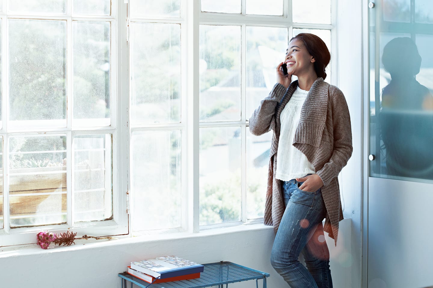 woman standing by the window using CenturyLink home phone service