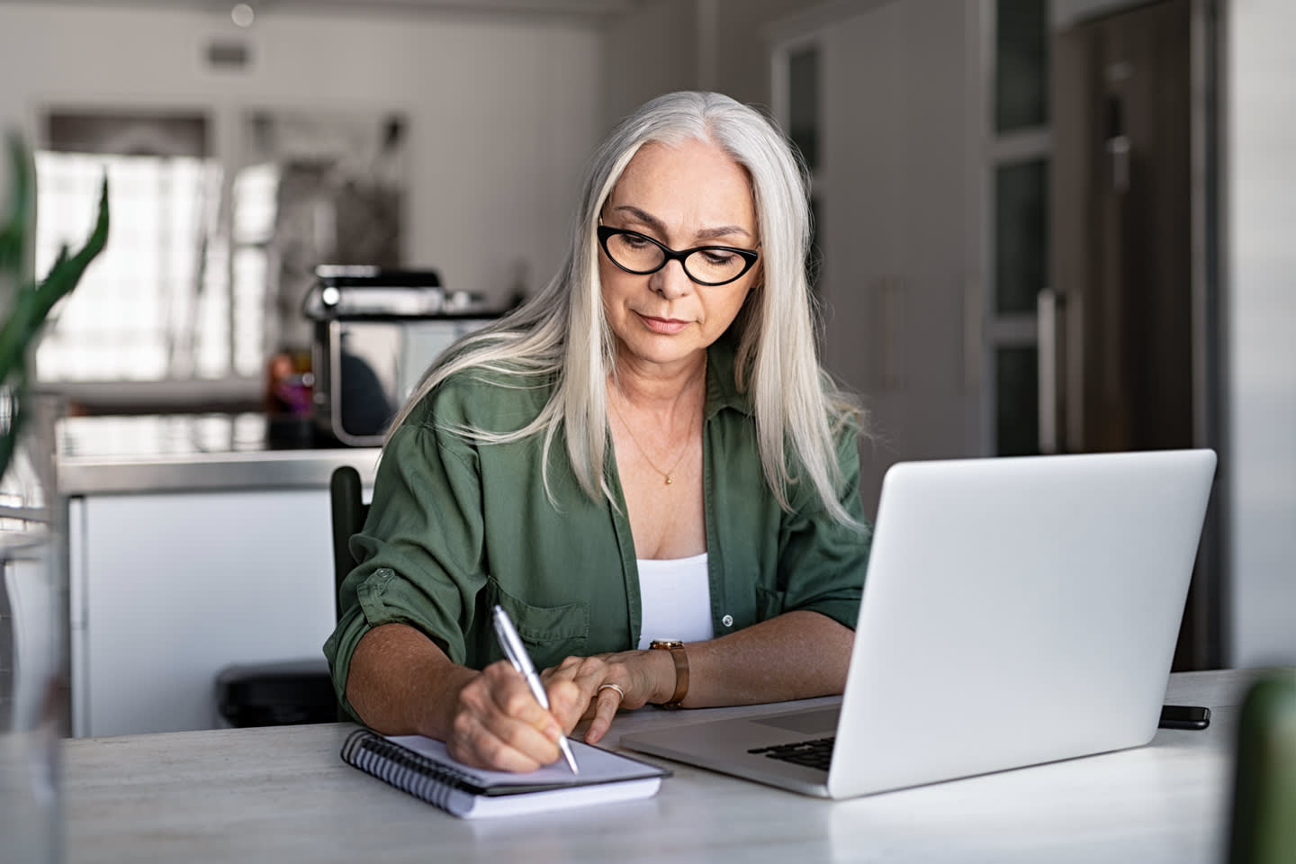 woman using CenturyLink internet on her laptop at the kitchen table