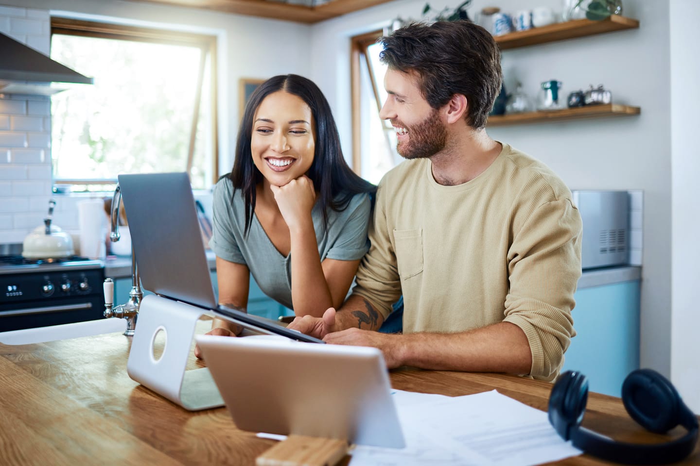 a couple in their kitchen using CenturyLink internet to work on their family budget