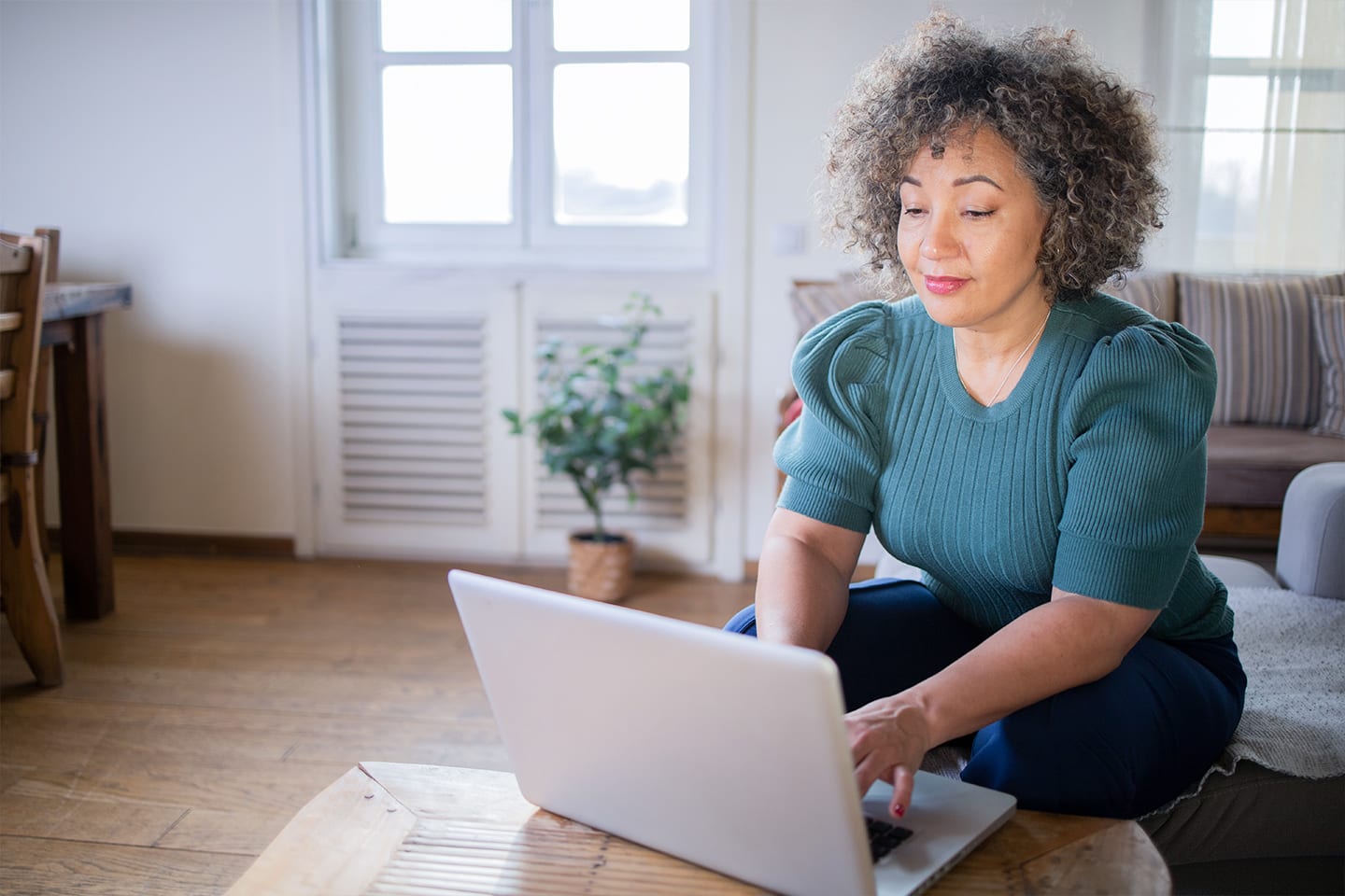 woman sitting on sofa with laptop